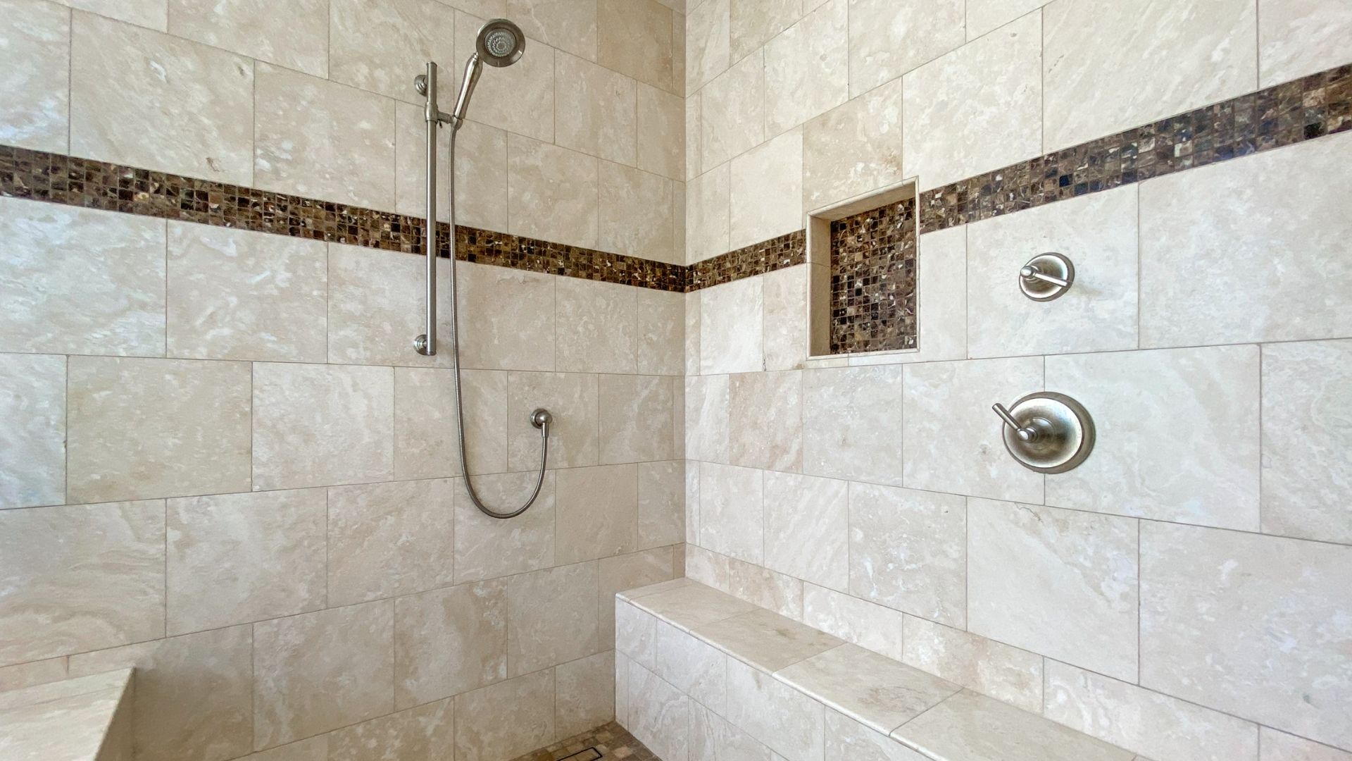 Bathroom tiling with a shower attached to the wall