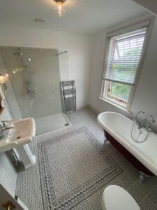 New bathroom installation with a new shower, sink, radiator and bath
