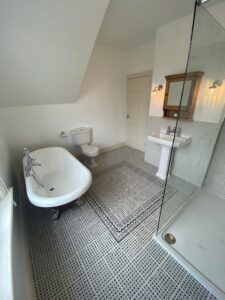 New bathroom installation with a new bath, sink, toilet and vanity cabinet