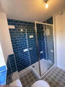 New bathroom installation with new shower and blue tiling