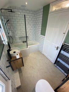New bathroom installation with a new bath, shower and radiator