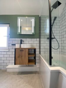 New bathroom installation with a new bath, shower and wooden sink with mirror