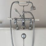 Traditional chrome bathtub faucet with handheld shower attachment, suitable for disabled bathroom designs.