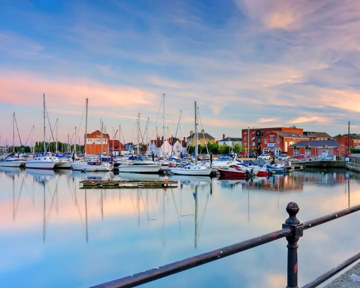 Marina at sunset with moored boats and reflective water, resembling the tranquility of a well-designed bathroom.