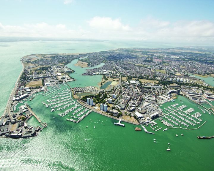 Aerial view of a coastal city with marinas, boats, and disabled bathroom installations.