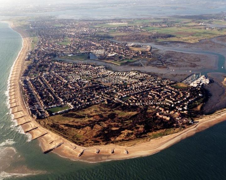 Aerial view of a coastal town with sea defenses, a river estuary, and bathroom tiling.