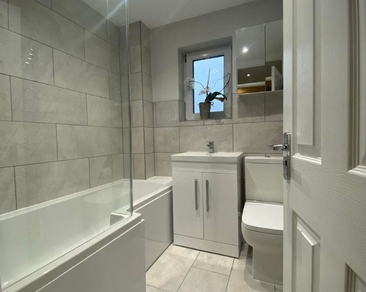 Modern bathroom design featuring a bathtub, toilet, and vanity.
