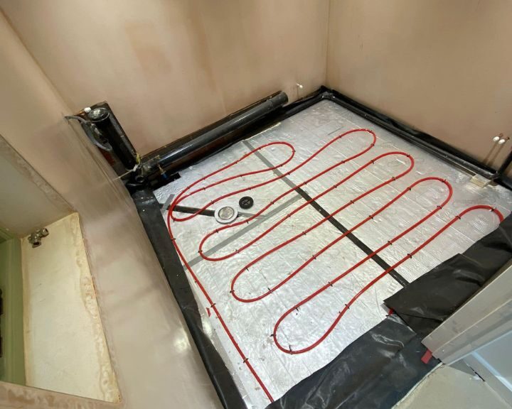 Installation of an underfloor heating system in a bathroom in progress.